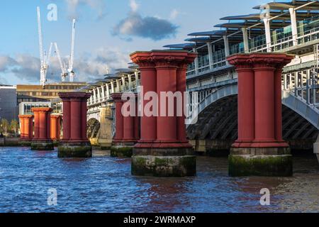 London, UK - 4. November 2013: Die Pfosten mit roten Säulen in der Themse neben der Blackfriars Railway Bridge sind alles, was von der Old BL übrig geblieben ist Stockfoto