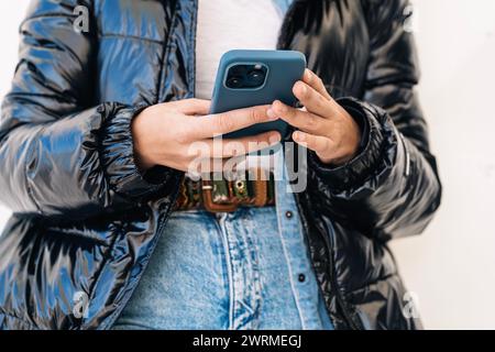 Die anonyme Person verwaltet ein Smartphone präzise und einfach und nutzt einen einzigartigen Vierfingergriff nach einer Daumenoperation, der Anpassungsfähigkeit zeigt Stockfoto