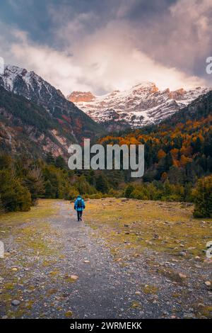 Rückansicht eines nicht erkennbaren Einzelgänger-Wanderers zu schneebedeckten Gipfeln im Bujaruelo Valley, Ordesa, Pyrenäen im Herbst. Stockfoto