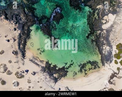 Diese Luftaufnahme fängt ein einzigartiges Herz, das in den Sand gezogen wird, an einem wunderschönen Strand in der Nähe des Vulkans Calderon Hondo auf Fuerteventura, vor dem atemberaubenden Hintergrund Stockfoto