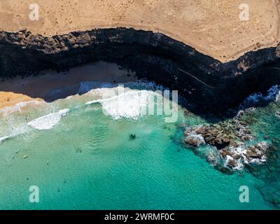 Ein Luftbild der Drohne zeigt das lebhafte türkisfarbene Wasser entlang der abgelegenen Sandstrände und zerklüfteten Klippen von Fuerteventura. Stockfoto