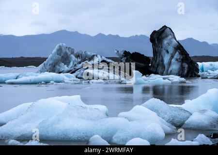 Eine eindrucksvolle Landschaft aus markanten Eisformationen inmitten der Gletscherlagune im Vatnajokull-Nationalpark, unter dem gedämpften Licht eines Islands Stockfoto