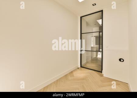 Ein Flur mit weißen Wänden und einer Glasschiebetür Stockfoto