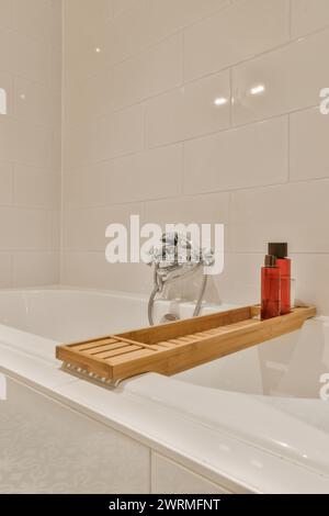 Eine weiße Badewanne mit einem Holztablett oben Stockfoto
