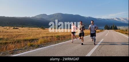 Eine Gruppe von Freunden, Athleten und Joggern nimmt die frühen Morgenstunden in Anspruch, während sie durch die nebelige Dämmerung laufen, die von der aufgehenden Sonne und angetrieben wird Stockfoto