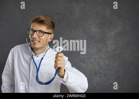 Hintergrund des Kopierraumes mit einem Porträt eines jungen männlichen Arztes, der ein Stethoskop hält Stockfoto