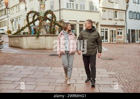 Liebe ein paar Touristen, die durch die Altstadt laufen. Ein paar Liebhaber schlendern gemütlich am kühlen Herbstmorgen durch die Straßen eines BIETIGHEIMS Stockfoto