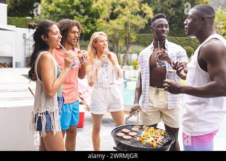Eine bunte Gruppe von Freunden genießt eine Grillparty im Freien Stockfoto