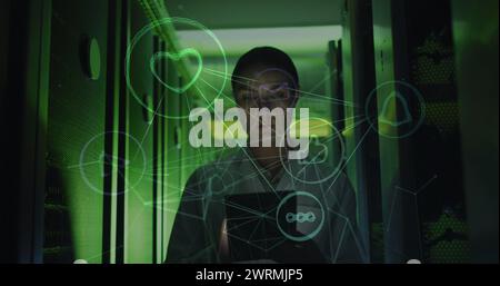 Bild des Netzwerks von Verbindungen und Symbolen über kaukasischer Serverraummärtnerin Stockfoto