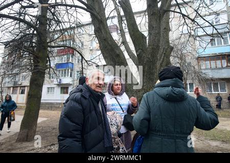 SUMY, UKRAINE - 13. MÄRZ 2023 - Menschen werden an der Stelle gesehen, an der eine der Drohnen russischer Truppen auf ein fünfstöckiges Wohngebäude in Sumy im Nordosten der Ukraine traf. Stockfoto