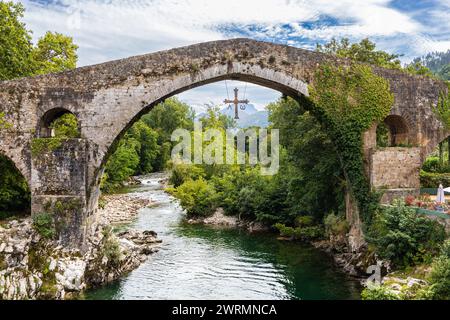 Römische Brücke in Cangas de Onis oder „Puentón“ über den Fluss Sella mit drei leicht spitzen Bögen. Asturien, Spanien. Stockfoto