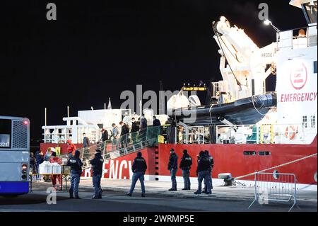 Die 52 geretteten Menschen steigen vom Rettungsschiff aus, während das Rote Kreuz darauf wartet, sie willkommen zu heißen. Life Support, das Rettungsschiff, das 52 Menschen rettete, kam im Hafen von Catania an. Sie wurden in internationalen Gewässern im libyschen Such- und Rettungsgebiet (SAR) gerettet. Stockfoto