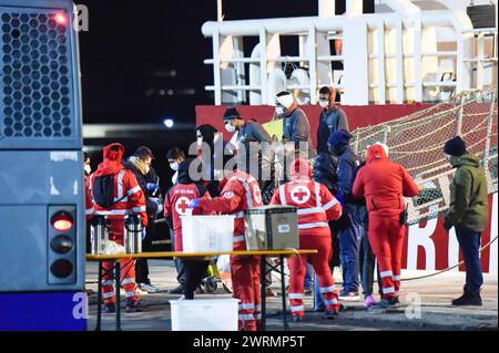 Das Rote Kreuz begrüßt die 52 geretteten Menschen beim Aussteigen aus dem Rettungsschiff im Hafen von Catania. Life Support, das Rettungsschiff, das 52 Menschen rettete, kam im Hafen von Catania an. Sie wurden in internationalen Gewässern im libyschen Such- und Rettungsgebiet (SAR) gerettet. Stockfoto