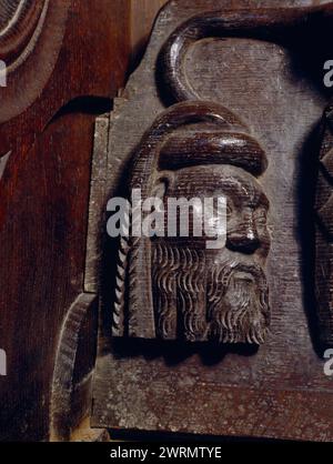 Der Kopf eines Adligen, der auf die Untersitze eines Miserikords in den Eichenchorstühlen im Chor der Beaumaris Parish Church in Anglesey, Wales, Großbritannien, geschnitzt wurde. Stockfoto