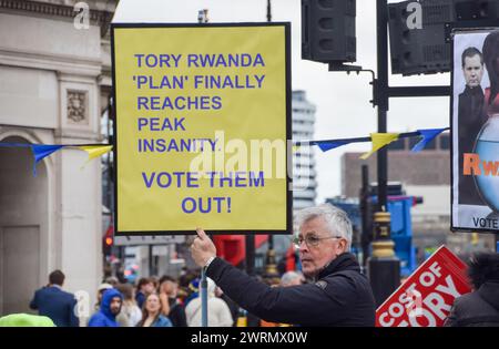 London, Großbritannien. März 2024. Ein Demonstrant hält ein Plakat, auf dem der Plan der Regierung für Asylsuchende während der Demonstration auf dem Parlamentsplatz kritisiert wird. Anti-Tory-Aktivisten versammelten sich zu ihrem wöchentlichen Protest, als Rishi Sunak Fragen des Premierministers stellte. Quelle: SOPA Images Limited/Alamy Live News Stockfoto