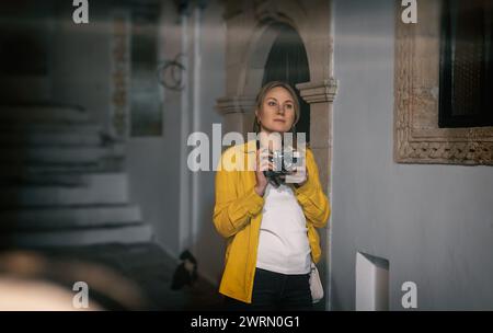 Eine Frau mit einer alten Kamera in der Altstadt. Stockfoto