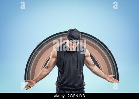 Starker, muskulöser junger Mann, der auf blauem Hintergrund herabblickt. Stockfoto