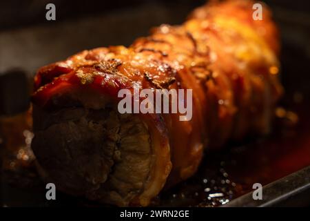 Gebackenes Schweinefleisch in ein Brötchen gewickelt. Pork Brötchen Nahaufnahme. Stockfoto