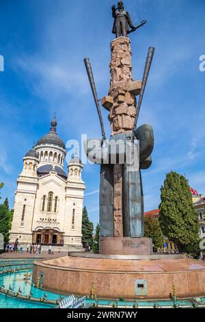 CLUJ-NAPOCA, TRANSSILVANIEN, RUMÄNIEN - 20. SEPTEMBER 2020: Statue von Avram Iancu auf dem Platz mit dem gleichen Namen und orthodoxe Kathedrale des Studentenwohnheims Stockfoto