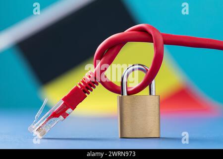 Ein geschlossenes Schloss auf einem gebundenen Netzkabel in einen Knoten vor dem Hintergrund der belgischen Flagge, das Konzept der Sicherheit von Internet-Technologien in der c Stockfoto