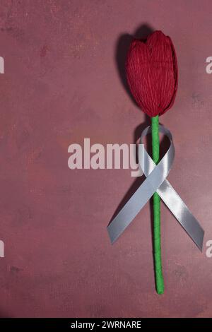 Rote Tulpe und graues Band. Parkinson Day-Konzept. Stockfoto