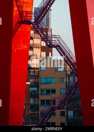 Ein hoher Wharf Crane in Göteborg, Schweden, verfügt über eine markante lila Treppe, die an der Seite hochsteigt. Die Treppe ist gegenüber den Gebäuden hervorgehoben Stockfoto