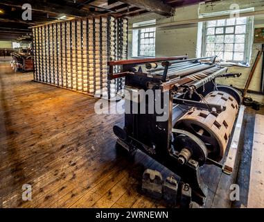 Wölbmaschine, die beim Weben von Baumwolle verwendet wird, mit Spulengestell dahinter. Quarry Bank Mill, Styal, Cheshire, Großbritannien Stockfoto