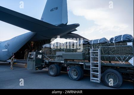 Zarqa, Jordanien. 11. März 2024. Ein Ladungsmeister der US-Luftwaffe platziert Paletten mit humanitärer Hilfe zum Verladen in die Frachtbucht eines C-130J Super Hercules-Flugzeugs der US-Luftwaffe auf der King Abdullah II Air Base am 11. März 2024 in Zarqa, Provinz Zarqa, Jordanien. Die Nahrungsmittelhilfe wird an palästinensische Flüchtlinge abgegeben, die vom israelischen Krieg gegen die Hamas gefangen sind. Foto: A1C Caleb Parker/US Air Force Photo/Alamy Live News Stockfoto