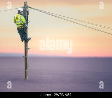 Linienmann (oder Linienarbeiter oder Techniker) in Einer abgelegenen Wüstenlandschaft, die Eine Telefonleitung repariert Stockfoto
