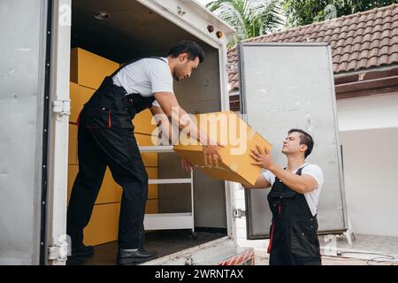 Uniformierte Mitarbeiter führen für den Kunden eine effiziente Entladung von Kartonagen aus dem Lkw durch Stockfoto