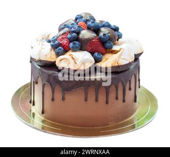 Schokoladenkuchen mit Erdbeeren, die in geschmolzene Schokolade, Himbeere, Heidelbeere und Meringue getaucht sind. Isoliert auf einfachem Hintergrund Stockfoto