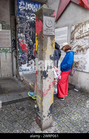 Ein Grenzposten der Deutschen Demokratischen Republik und ein Teil der ursprünglichen Berliner Mauer in der Nähe des Checkpoints Charlie in Berlin. Stockfoto