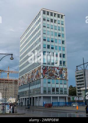 Das Haus des Lehrers mit einem Gebäude aus den 1960er Jahren, das mit einem lebhaften Wandgemälde im mexikanischen Stil dekoriert ist, in der Nähe des Alexanderplatzes in Berlin. Stockfoto