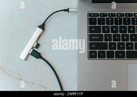 Nahaufnahme eines usb-Hubs vom Typ c mit mehreren verschiedenen Anschlüssen, die an den Laptop angeschlossen sind Stockfoto