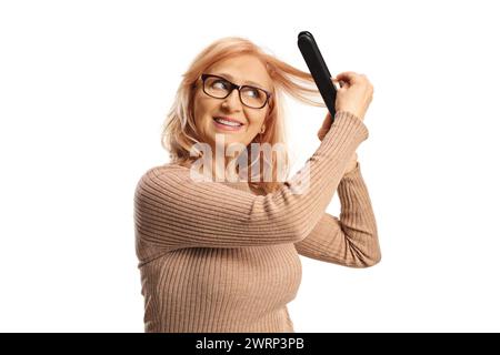 Frau, die einen kabellosen Haarglätter auf weißem Hintergrund verwendet Stockfoto