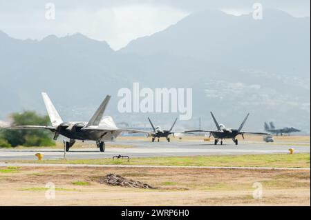 F-22 Raptors, betrieben von den 199th und 19th Fighter Squadrons, Taxi hinter einem F-15 Eagle, zugewiesen dem 173rd Fighter Wing, 7. März 2023, in der Joint Base Pearl Harbor-Hickam, Hawaii. Flugzeuge und Personal aus Kingsley Field, Oregon, trainierten zusammen mit den lokalen F-22 Raptors im Rahmen einer zweiwöchigen Übung namens Sentry Luau. (Foto der U.S. Air National Guard von Tech. Herr John Linzmeier) Stockfoto