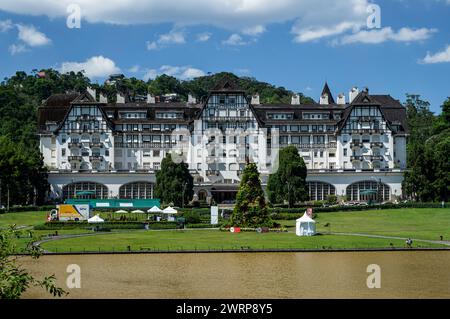 Vorderansicht des Quitandinha Palace, ein historisches ehemaliges Resorthotel und berühmtes Wahrzeichen von Petropolis unter dem sonnigen, wolkenblauen Himmel. Stockfoto