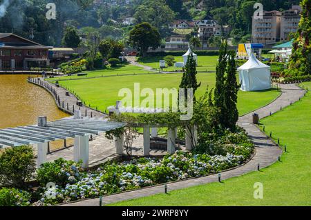 Teilweiser Blick auf den Quitandinha Palast, grüne und gepflegte Gärten am Quitandinha See im Quitandinha Viertel unter Sommernachmittag sonnigen Tag. Stockfoto