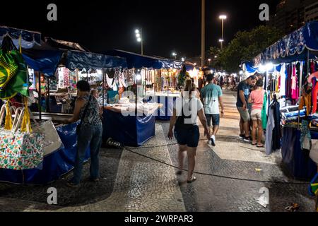 Blick auf die freien Marktstände der Copacabana, die nachts in der Atlantica Avenue am Copacabana Beach laufen, Posto 5 Abschnitt Gehweg im Copacabana District. Stockfoto