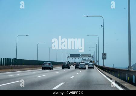 Verkehrsbewegung über die Rio Niteroi-Brücke (Mario Covas Highway) bei KM 329 während der Fahrt nach Niteroi-Stadt unter dem sonnigen, klaren blauen Himmel am Sommernachmittag. Stockfoto