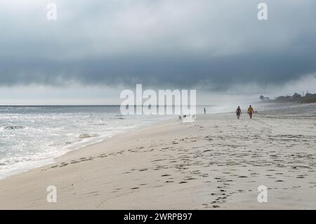 Ruhiges, blaues Wasser des atlantiks, das unter dem wolkenbewölkten blauen Himmel am Sommernachmittag auf den weißen Sand des leeren Praia Seca-Strandes trifft. Stockfoto