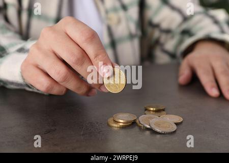 Die arme Frau zählt Münzen am grauen Tisch, Nahaufnahme Stockfoto