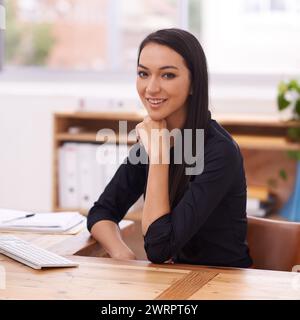 Büro, glücklich und Porträt einer asiatischen Geschäftsfrau am Schreibtisch mit Zuversicht, Stolz und positiver Einstellung. Professional, Consultant und Porträt von Stockfoto