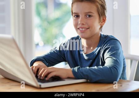 Zuhause, Junge und Kind mit Laptop in Smile für Online-Lernen mit Entwicklung, Wachstum und Lernen von Kindern. Hausaufgaben, Internet und Recherche mit Notizen für Stockfoto