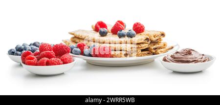 Frisch zubereitete Crepes mit Himbeeren, Heidelbeeren und einer Seite Schokolade auf weißem Hintergrund. Stockfoto