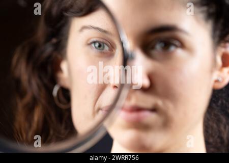 Künstlerische Darstellung des Gesichts einer Frau, halb im Spiegel gesehen Stockfoto