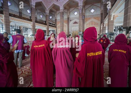 Putrajaya, Malaysia 14. März 2024 . Weibliche Besucher in der pinken Moschee von Putra während des heiligen Monats Ramadan in rosafarbenen Gewändern mit Kapuze, um den konservativen muslimischen Kleidercode zu entsprechen Stockfoto