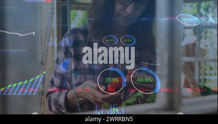 Bild von digitaler Datenverarbeitung und leuchtendem Licht über dem Kochen von weissfrauen Stockfoto