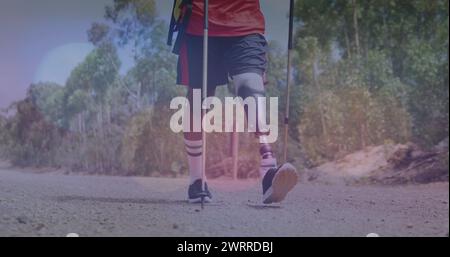 Bild von Lichtflecken über behinderten birassischen Männern, die in Bergen laufen Stockfoto