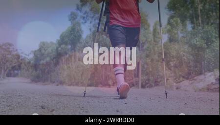 Bild von Lichtflecken über behinderten birassischen Männern, die in Bergen laufen Stockfoto